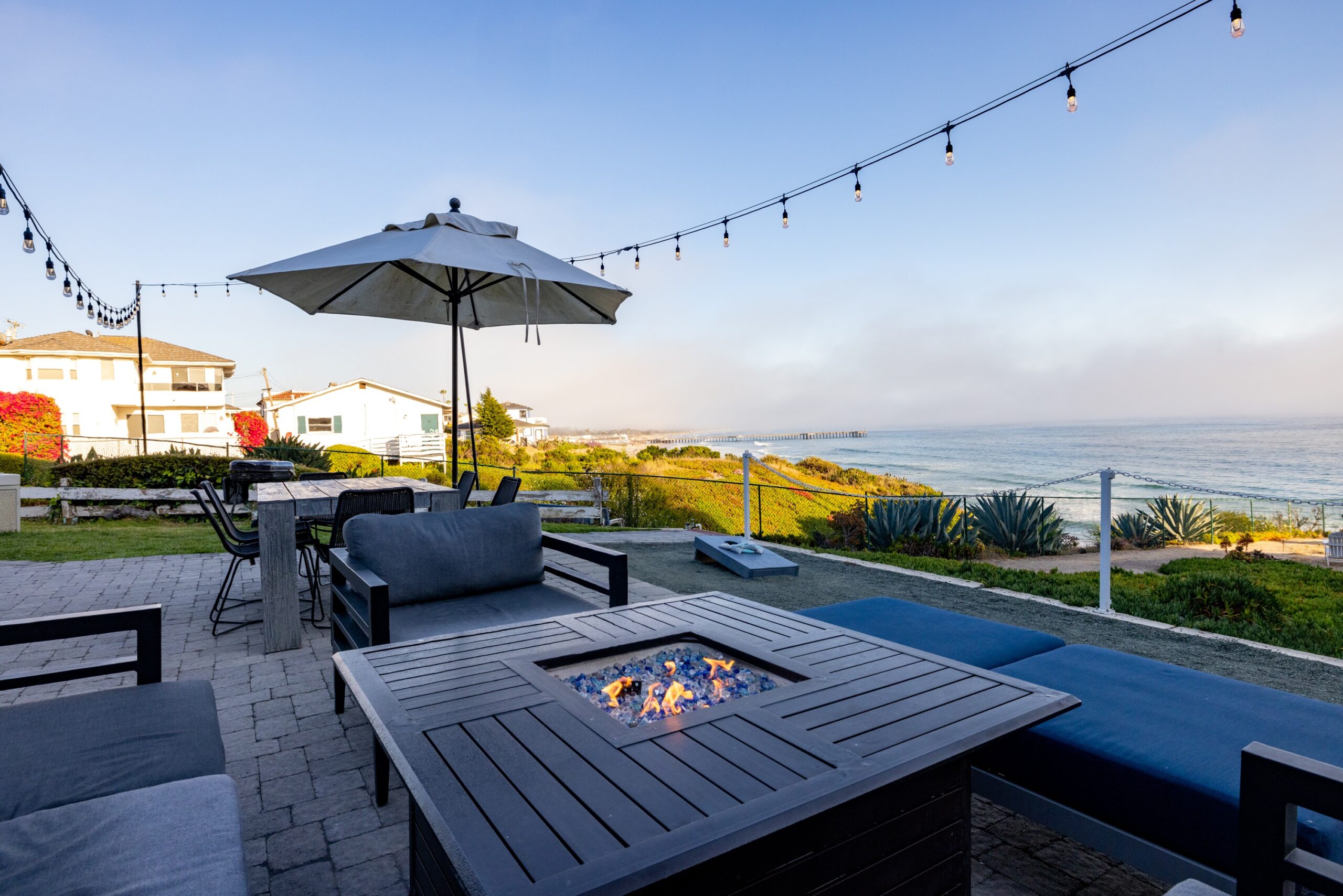 Fire pit and umbrella on patio with ocean view