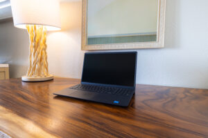 Laptop on a wooden desk in hotel room