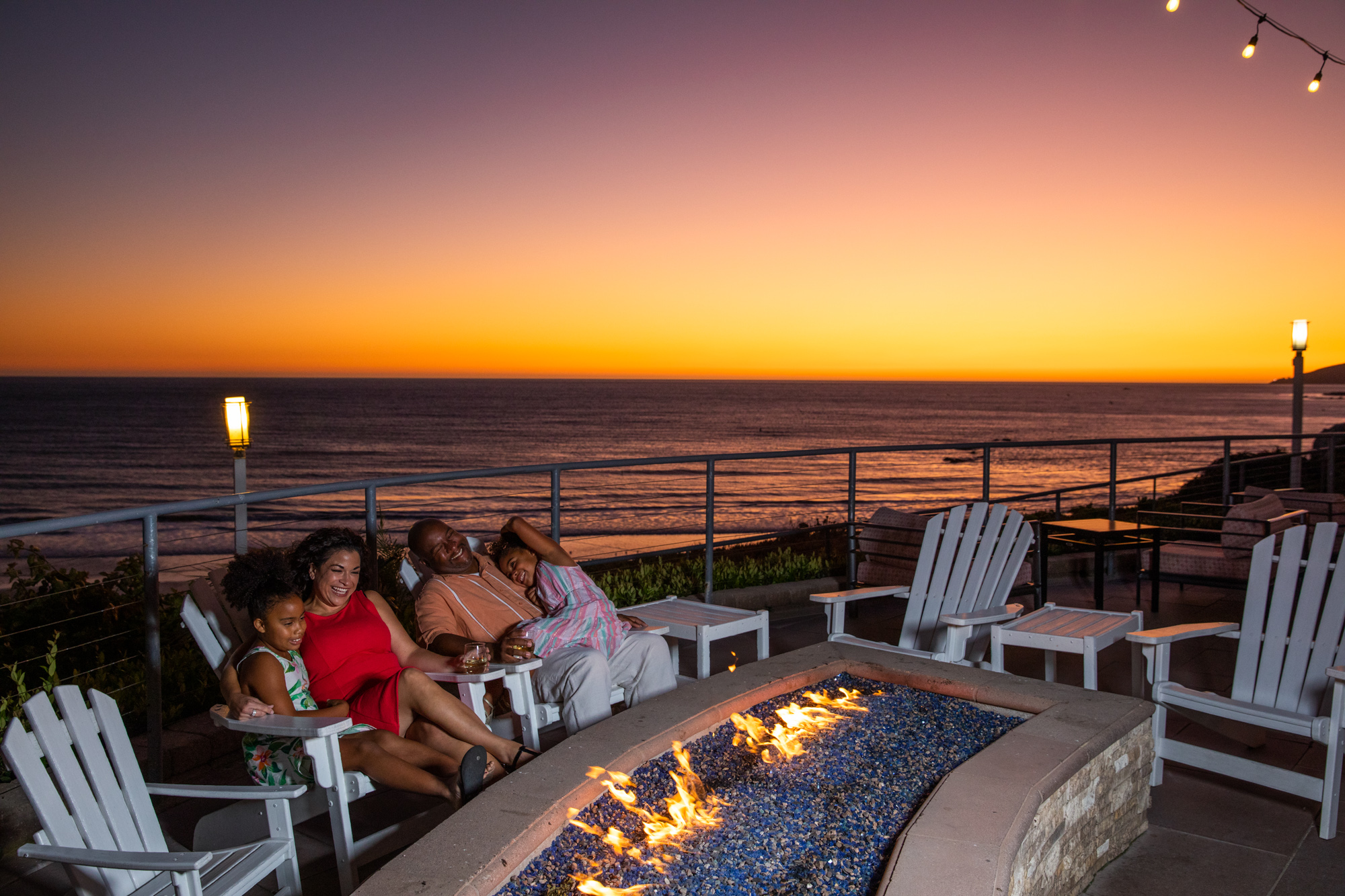 Family at fire pit during sunset at SeaCrest OceanFront Hotel